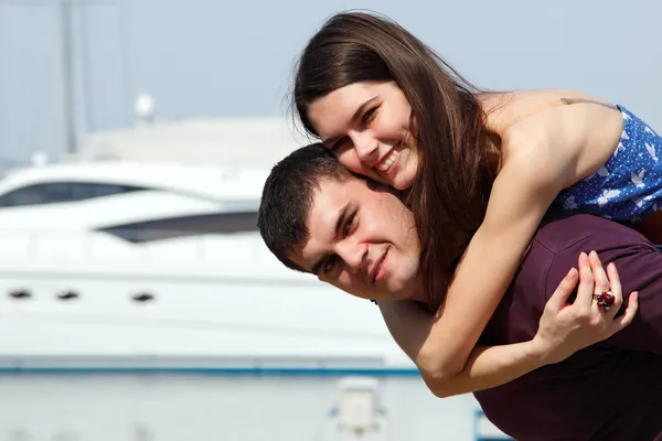 Abraços de par caucasianos bonitos jovens e beijo - primeiro amor no porto — Fotografia de Stock