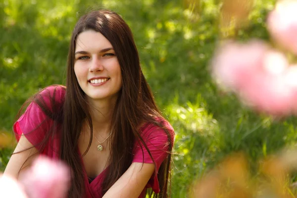 Atractiva sonrisa adolescente chica relajarse en primavera verde hierba — Foto de Stock
