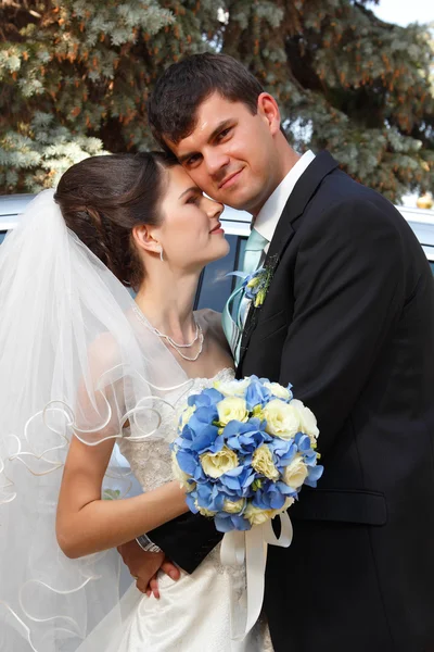 Mooie jonge bruid hugs bruidegom in liefde — Stockfoto
