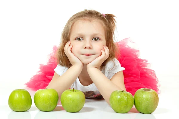 Sevimli küçük kız yalan ve elma ile playng — Stok fotoğraf
