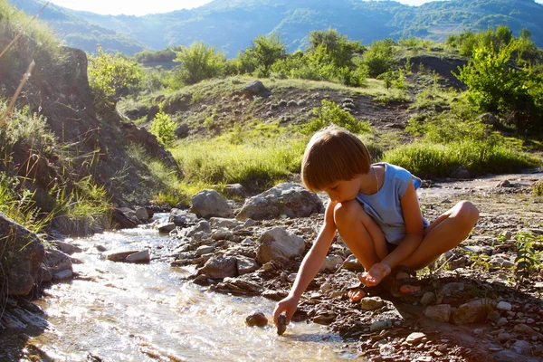 Boy play on mountain river — Stock Photo, Image