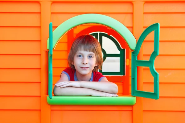 Маленький мальчик играет в игрушечном домике — стоковое фото