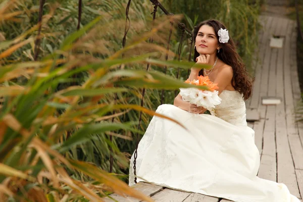 Retrato de novia sentada en el puente —  Fotos de Stock