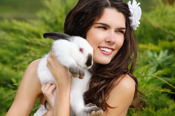 여 자가 웃 고 귀여운 토끼를 들고 — 스톡 사진