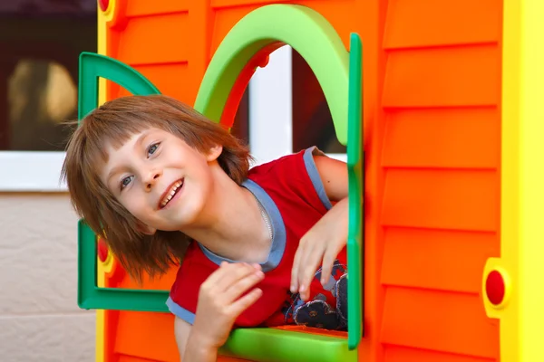 Bonito menino brincando em casa de brinquedo — Fotografia de Stock