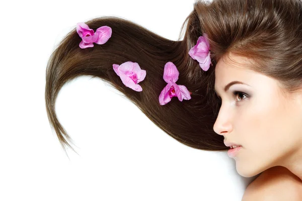 Mujer joven con orquídea púrpura — Foto de Stock