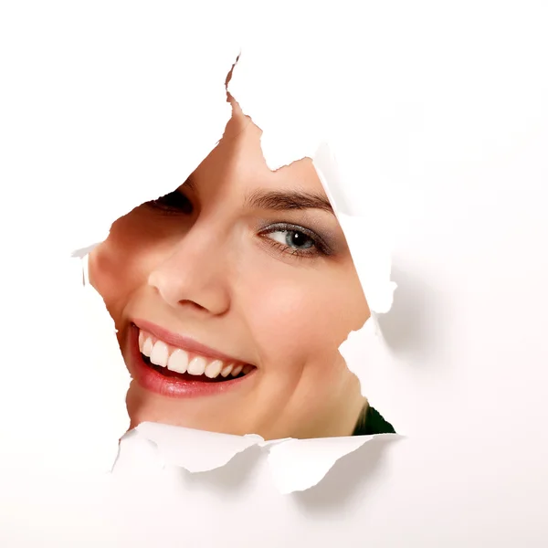 Girl peeping surprised through hole in paper — Stock Photo, Image