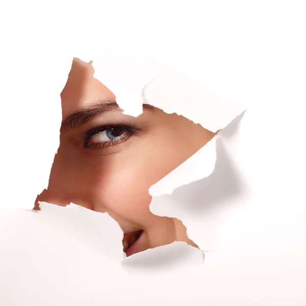 Girl peeping surprised through hole of paper — Stock Photo, Image