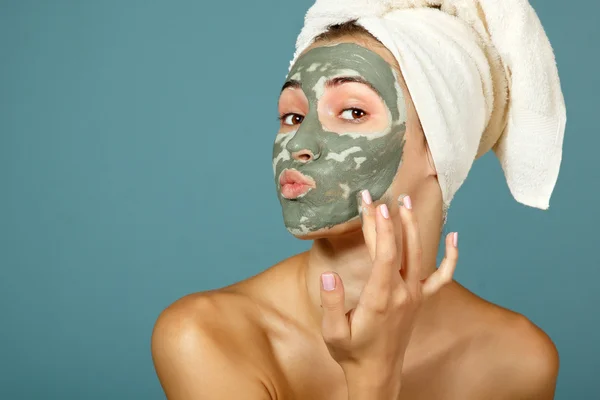 Menina adolescente aplicando máscara de barro facial — Fotografia de Stock