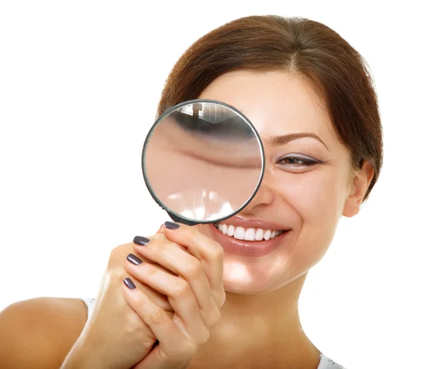 Woman looking through a magnifying glass Stock Image