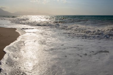 Sicilya, İtalya 'da gün batımında plaj. Akdeniz ve dağlarla çevrili manzara