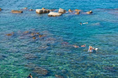 Denizde yüzen turistler, manzaralı. Sicilya, İtalya 'da plaj. 