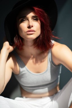 Çilli, güzel, genç, kızıl bir kadın. Sıradan kıyafetler ve şık şapkalar giyen çekici bir kızın moda portresi.