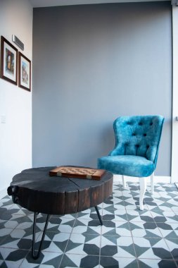 Modern tasarım ev tasarımı, zarif mavi koltuklu retro tarzı ve gri duvarın üzerinde siyah ahşap sehpa. Tarz ev dekoru