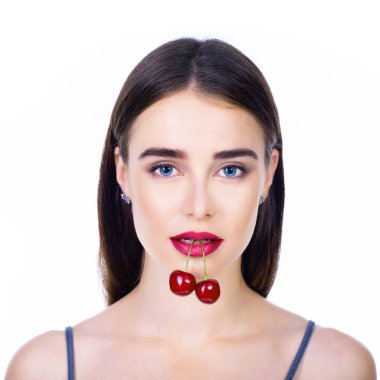 Olgun kirazlı genç ve güzel bir kadın. Taze kırmızı kirazlı güzel bir kadın. Güzel makyajlı ve beyaz arka planda izole edilmiş kiraz meyveli çekici bir kadın..