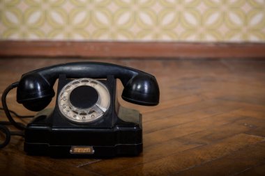 Retro siyah telefon parke zemininde 20. yüzyılın 60-70 'li yılların detaylı iç mimarisi olan eski duvar kağıtlarına karşı.