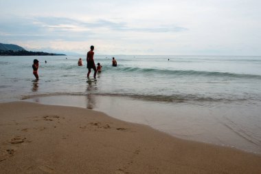 Günbatımında Sicilya 'da (İtalya) sakin Akdeniz' de yüzen insanlar