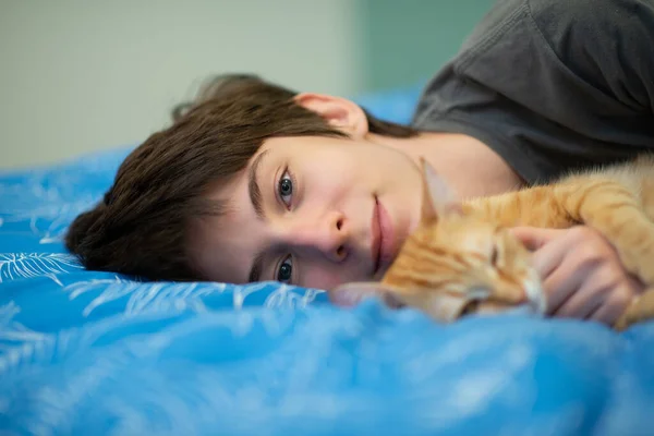 Αστεία Νεαρή Κόκκινη Τιγρέ Γάτα Κοιμάται Μαζί Έφηβο Αγόρι Στο — Φωτογραφία Αρχείου