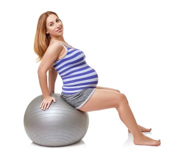 Koca göbekli hamile bir kadın, beyaz arka planda stüdyoda spor egzersizleri yapıyor. Hamilelik ve sağlıklı aktif yaşam tarzı