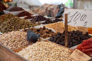 Baharatlar, kurutulmuş kestaneler, fındık, şekerli meyve, tuzlu zeytinler açık hava pazarında lehimleniyor, Sicilya, İtalya
