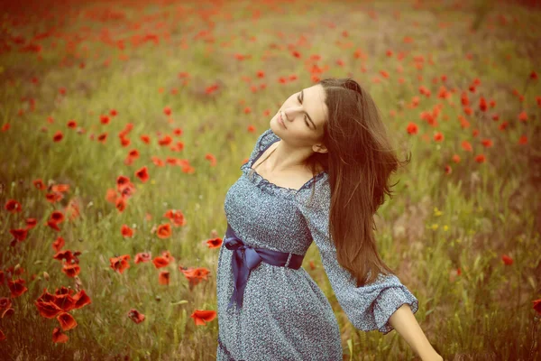 身穿蓝色夏衣的年轻漂亮的女人在罂粟地里散步 迷人的女孩在雨前散步 大自然在室外 — 图库照片