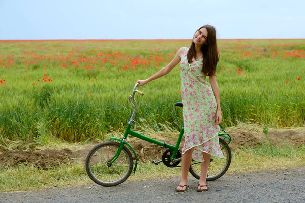 若い自転車の美しい女性は ケシ畑 夏の屋外を歩いています 魅力的な笑顔の女の子とともにレトロバイク — ストック写真