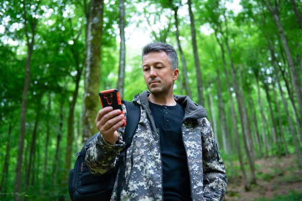 Dojrzały Mężczyzna Spacery Wędrówki Lesie Górskim Przy Użyciu Telefonu Komórkowego — Zdjęcie stockowe