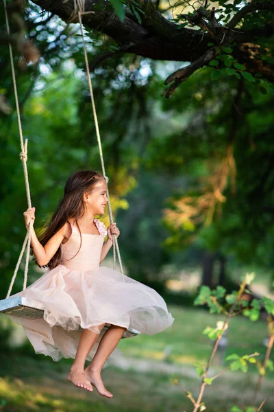 幸せな女の子は公園でスイングに乗っています リトルプリンセスは楽しい屋外 夏の自然屋外があります 子供時代 子供のライフスタイル 楽しみ — ストック写真