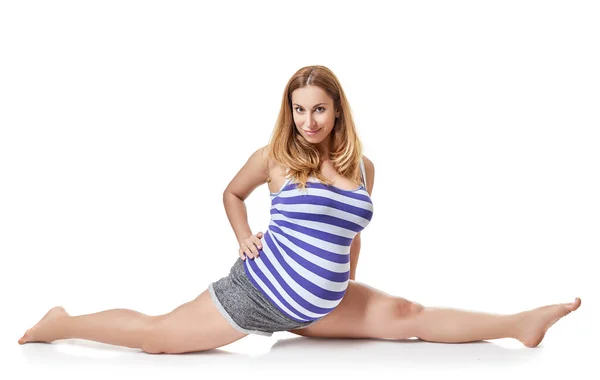 大きな腹を持つ妊婦はスポーツ演習を行い 白い背景の上にスタジオで双子に座っています 健康的なアクティブライフスタイル — ストック写真