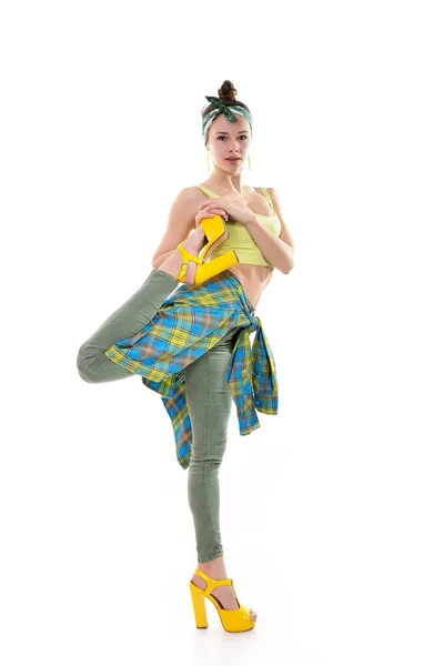 穿着长统袜和黄色高跟鞋的年轻貌美姑娘在白底的工作室里跳舞 — 图库照片