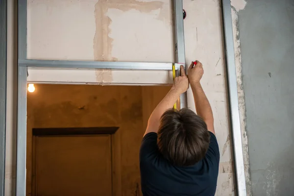 男工从事干墙剖面 刻划标记的工作 建筑工程 翻修工程 — 图库照片
