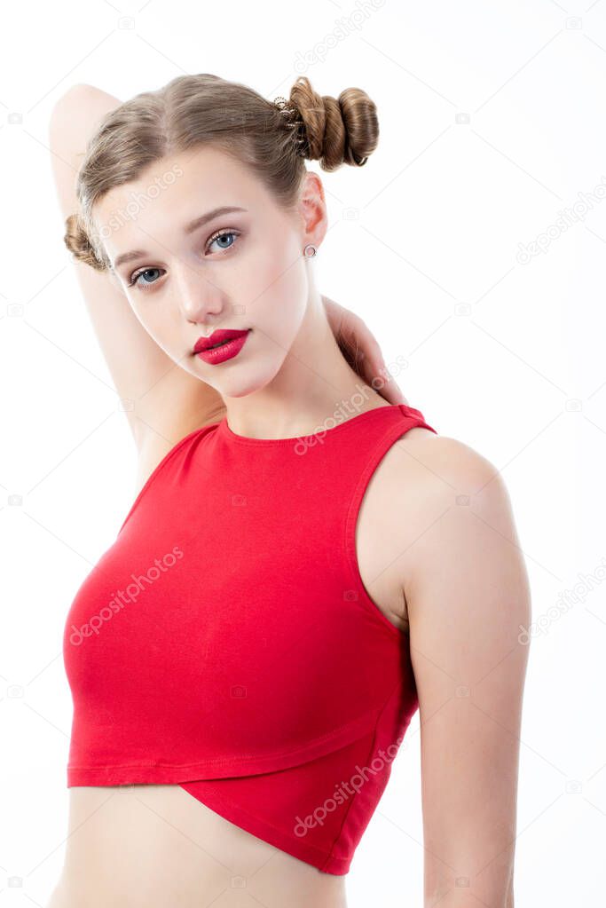 Young charming woman wearing red top posing at studio over white background