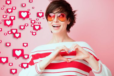 Hoşlanmak. Evrensel aşk, kabullenme, popülerlik ve sosyal ağlarda başarı. Sahte duygular. Mutlu gülümseyen kız aşkı hisseder, minnettar. Genç bir kadın kameraya gülümsüyor elleri ve öpücükleriyle kameraya bakıyor.