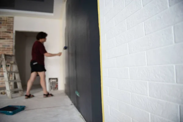 滚筒墙绘画 工人油漆墙壁 家居翻新 重点放在白砖上 画家在工作 家庭翻新 — 图库照片