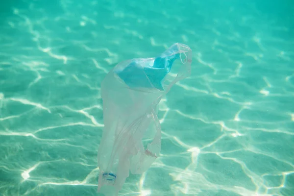 海洋汚染だ 個人用保護マスク プラスチックボトルとバッグ水中 外科的マスクの過剰使用とコロナウイルスパンデミック時の不適切な廃棄物処理の結果 — ストック写真