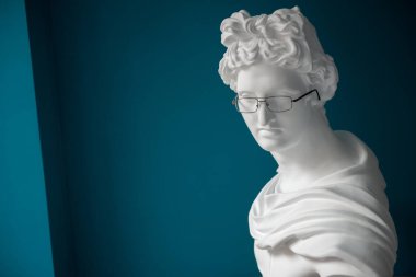 Gözlüklü alçı heykel kafası. Antika ve modernlik. Miyop ve hiperopi tedavisi kavramı