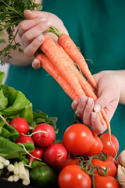 Vrouw met wortels in haar hand — Stockfoto