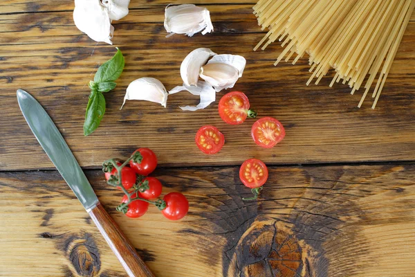 Espaguetis, tomates cherry y ajo. Cocinar la cena — Foto de Stock