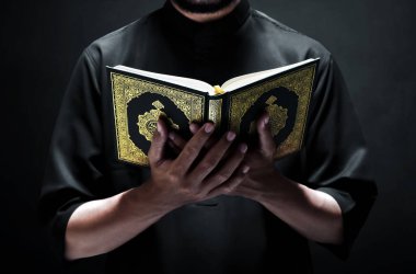 Dindar Müslüman adam kutsal Kuran 'ı okuyor.