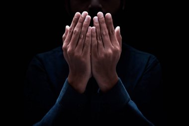 Müslüman adam karanlık arka planda dua ediyor