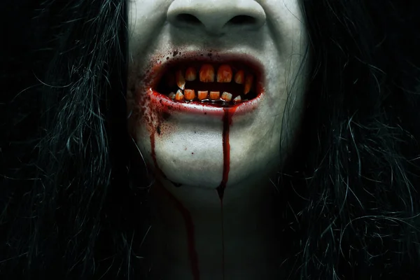 Scary vampire teeth on dark background