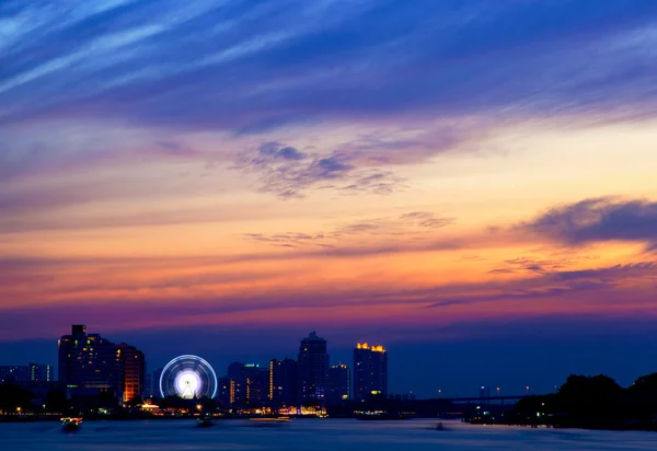 Cerca de un río al atardecer. Había luz en el edificio. . — Foto de Stock