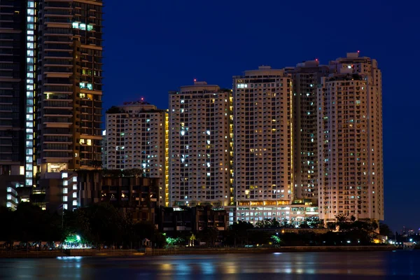 Condominiums and skyscrapers at night.