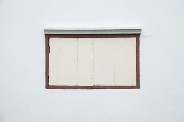 Vieja ventana en una pared blanca . — Foto de Stock
