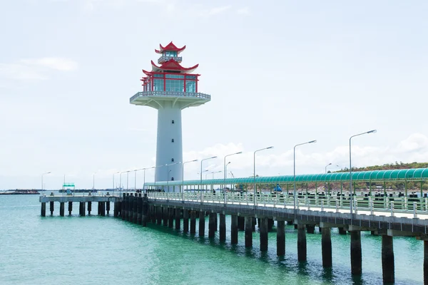 Vuurtoren brug die zich uitstrekt in de zee. — Stockfoto