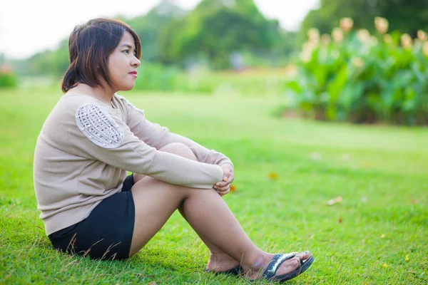 Porträtt asiatisk kvinna sitter i parken. — Stockfoto