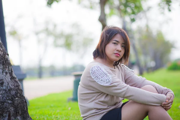 Портрет азиатской женщины, сидящей в парке . — стоковое фото