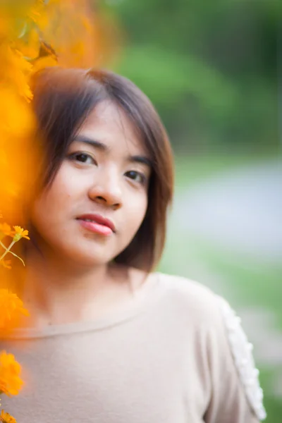 Retrato Mujer asiática de pie cerca de flores amarillas . — Foto de Stock