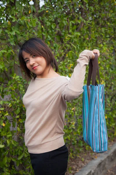 Портрет азиатской женщины, стоящей и держащей сумку — стоковое фото