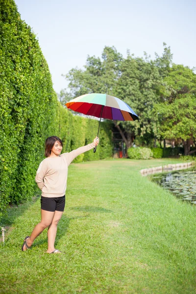 Mujer asiática sosteniendo un paraguas en el parque . — Foto de Stock